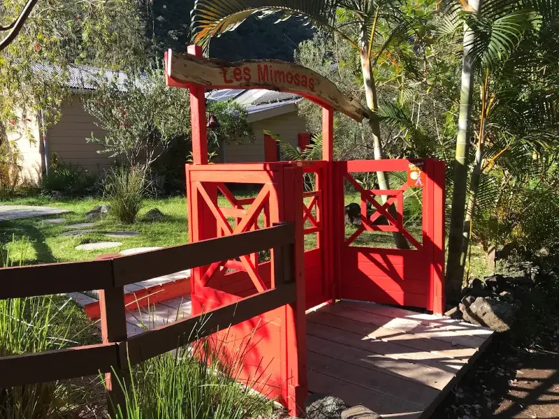 Entrée de la chambre d'hôtes Les Mimosas : portail rouge et enseigne en bois, Grand-Bassin, La Réunion